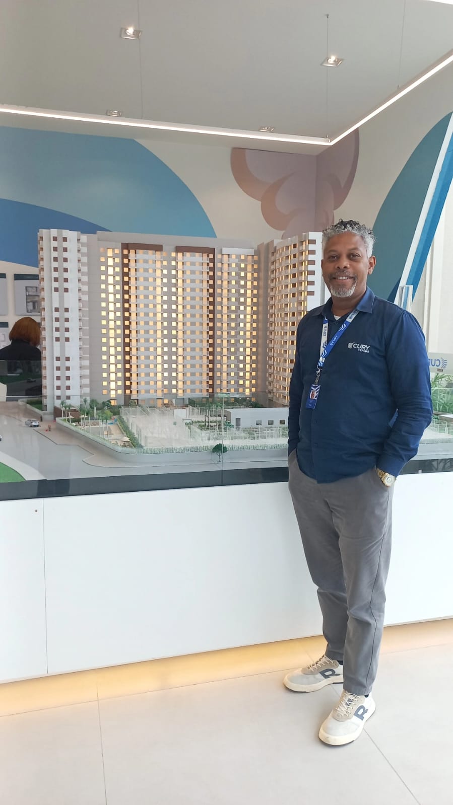 Lander Reyz em frente à maquete de um empreendimento Cury